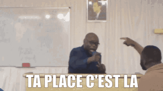 a man giving a speech with the words ta place c'est la written on the bottom
