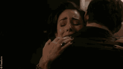 a woman is hugging a man with a freeform logo on the bottom right
