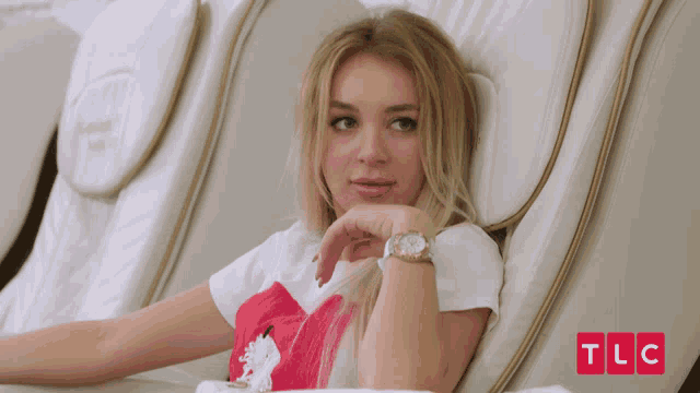 a woman is laying in a chair with tlc written in red