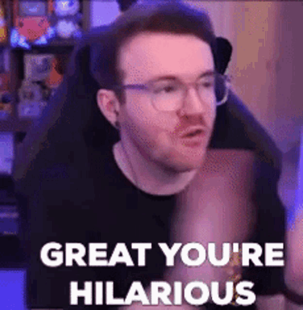 a man wearing glasses is sitting in a chair with the words `` great you 're hilarious '' written on it .