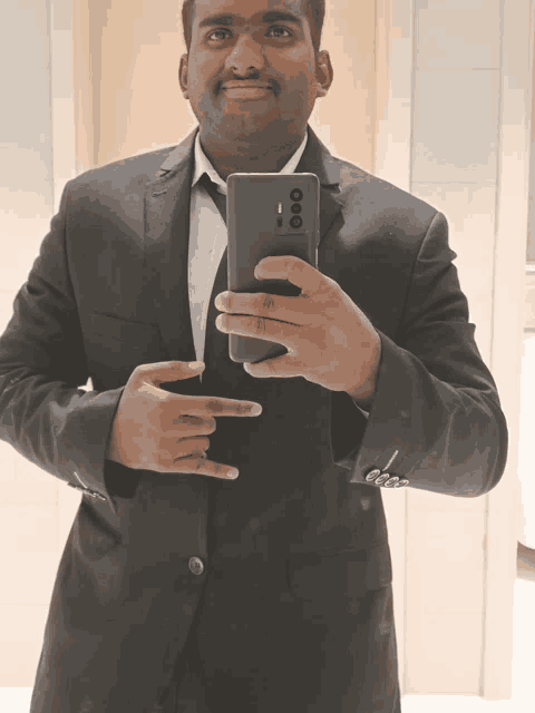 a man in a suit is taking a picture of himself with his phone