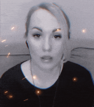 a woman wearing headphones looks at the camera with sparks flying around her