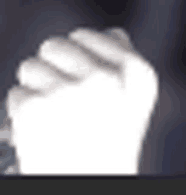 a person 's fist is visible in a blurry photo .