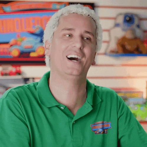 a man wearing a green shirt with a logo for hot wheels on the front