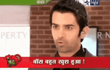 a man is on a television screen with a brick wall behind him