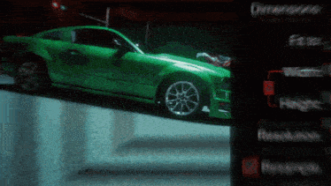 a green car is parked in front of a sign that says different fuels