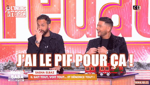 two men are sitting in front of a sign that says j ai le pif pour ca