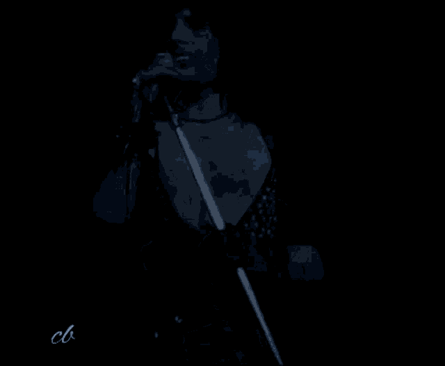 a man is singing into a microphone in a dark room while wearing black gloves .