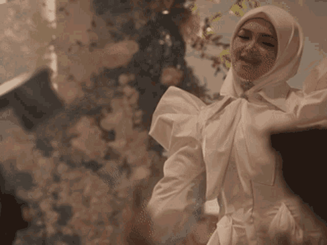 a woman wearing a white hijab and a white shirt