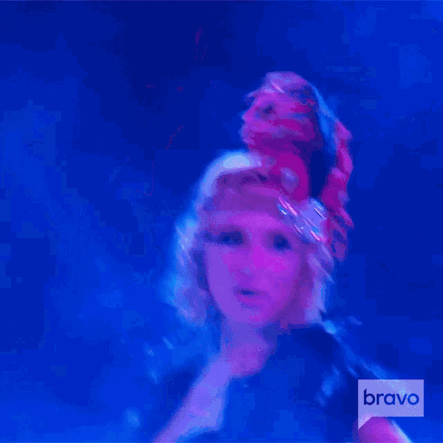 a woman is dancing in front of a sign that says bravo on it