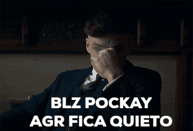 a man in a suit covering his face with his hand and blz pockay agr fica quieto written below him