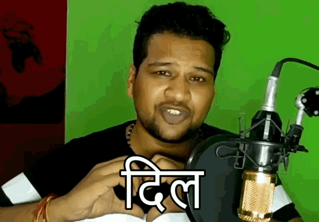 a man is standing in front of a microphone with the word dil written on his face