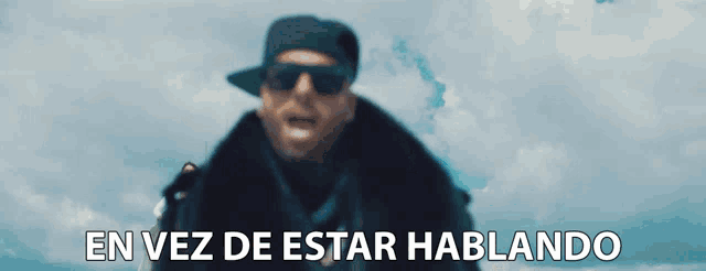 a man standing on top of a building with the words " en vez de estar hablando " below him