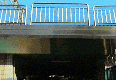 a bridge with a railing and a blue sky behind it