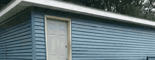 a blue house with a white door and a roof