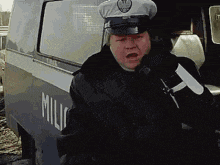 a police officer in front of a van that says mili