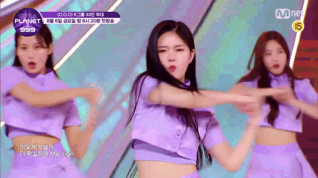 a girl in a purple crop top is dancing in front of a group of girls .