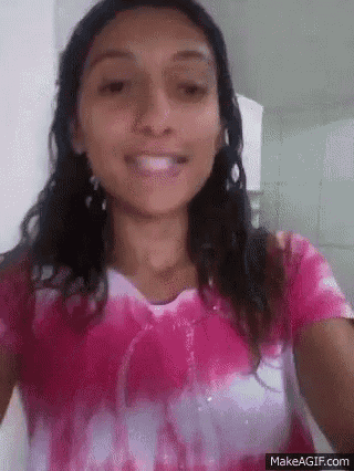 a woman in a pink and white tie dye shirt is smiling .