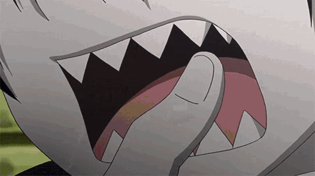 a close up of a person 's mouth with sharp teeth and a pink tongue