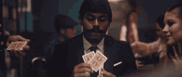 a pile of money and playing cards with a king and queen on top