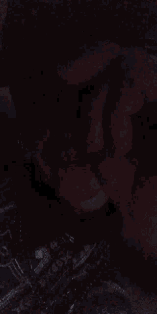 a blurry picture of a person laying on a bed with a dark background