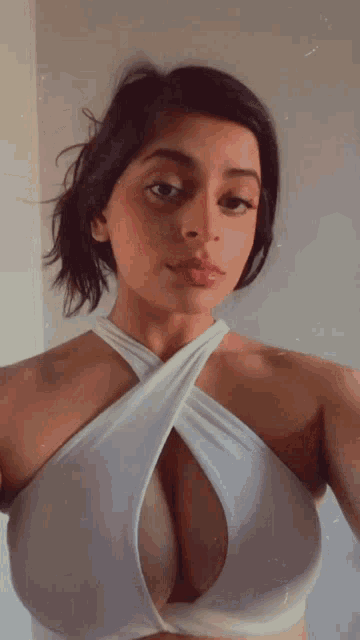 a woman taking a selfie with her breasts showing
