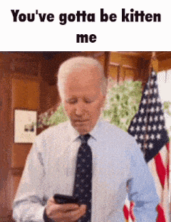 a man in a suit and tie is looking at his phone .