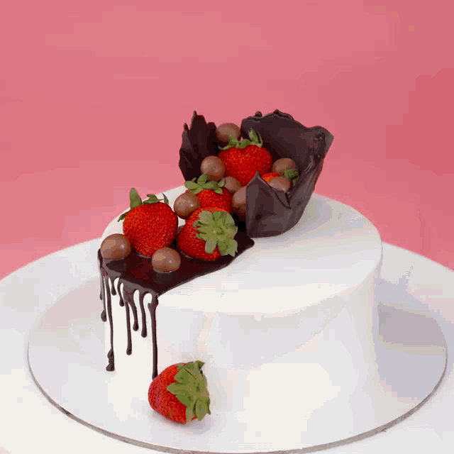 a white cake with strawberries and chocolate chips on top