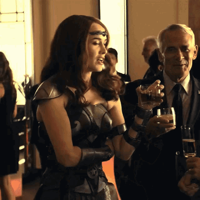 a woman in a wonder woman costume holds a glass of water