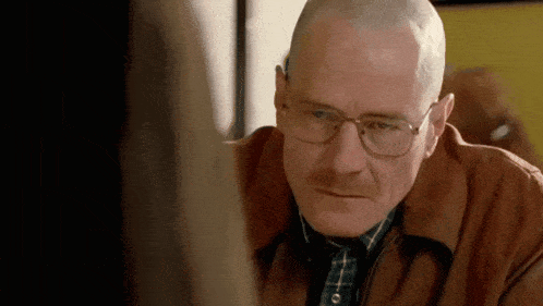 a bald man wearing glasses and a brown jacket looks at a woman .