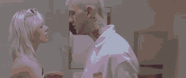 a man and a woman are kissing in front of a window in a purple room .