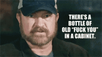 a man with a beard is wearing a hat and says there 's a bottle of old fuck you in a cabinet