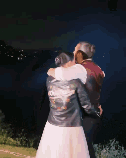 a bride and groom are hugging and the bride is wearing a leather jacket with the word love on it