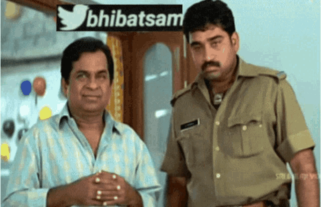 two men are standing in front of a sign that says ' bhibatsam ' on it