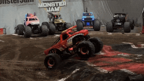 several monster jam trucks are lined up on a track