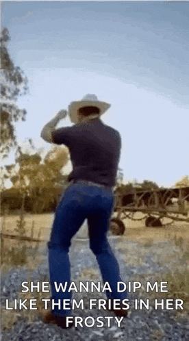 a man in a cowboy hat is dancing in a field with a quote .