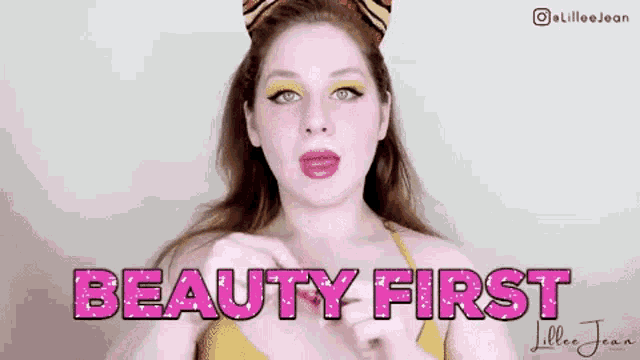 a woman is wearing a tiger ear headband and the words beauty first are behind her