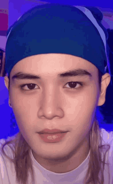 a young man wearing a blue headband and a white shirt