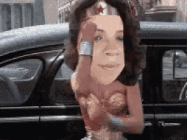 a woman dressed as wonder woman is standing in a car