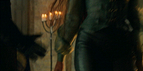 a person holding a menorah in front of a candle holder
