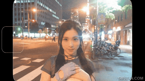 a gif from gifrun.com shows a woman standing on a street