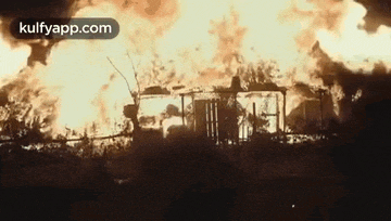 a house is on fire in the middle of a field .