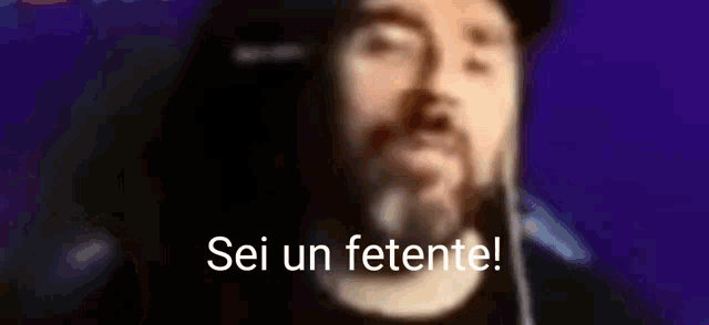 a blurry picture of a man with a beard and the words sei un fetente .