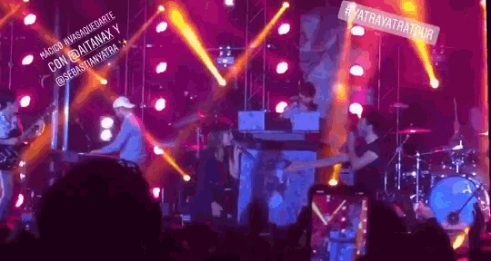 a group of people playing instruments on a stage with a sign that says #atravatratour