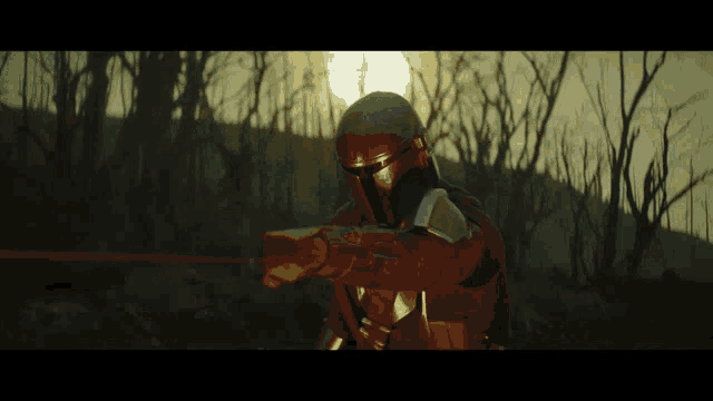 a man in a helmet is holding a sword in front of a forest
