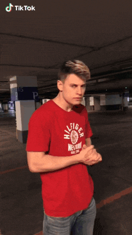 a man wearing a red t-shirt that says hilfiger new york on it