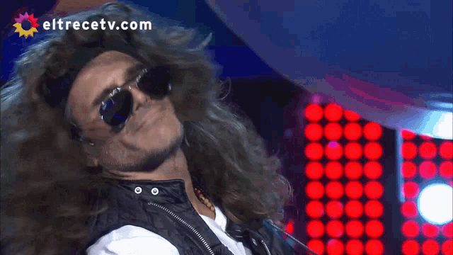 a man wearing sunglasses is on a television screen with eltrecetv.com written on the bottom