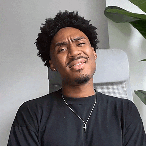 a man wearing a black shirt and a cross necklace is making a face