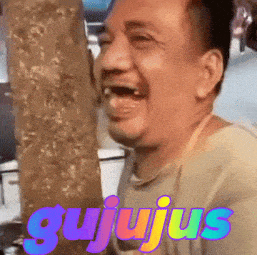 a man is laughing while holding a giant ice cream cone in his mouth .