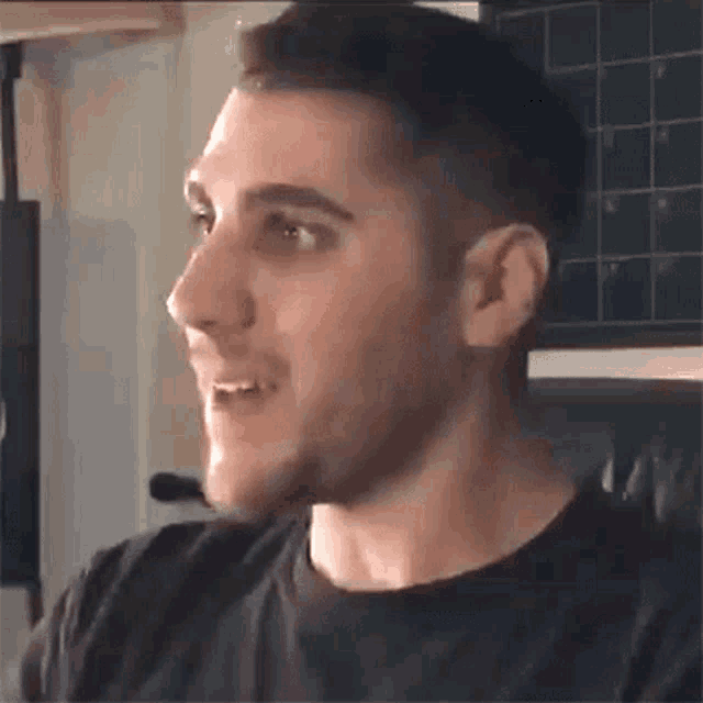 a close up of a man 's face with a black shirt
